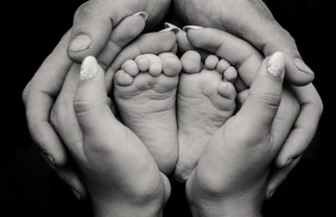 greyscale photography of human feet and hand