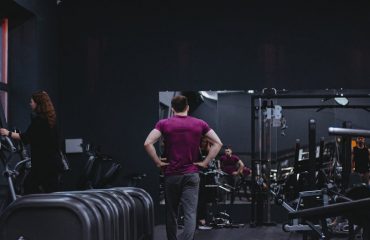 Man in a gym with fitness equipment, highlighting a healthy lifestyle.